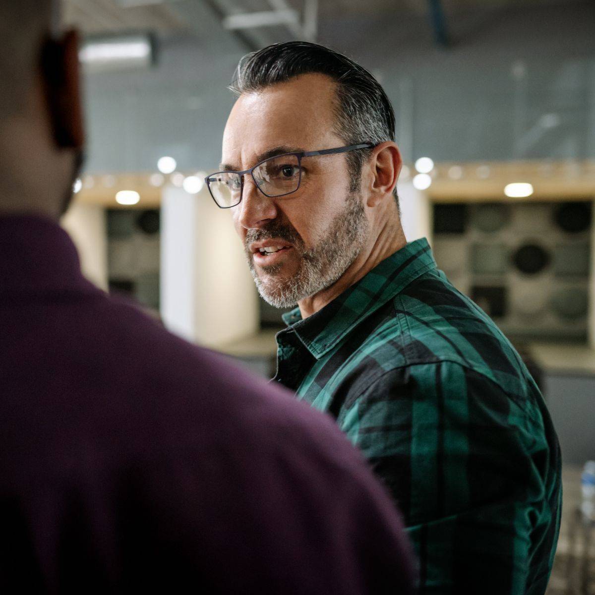 歩きながら同僚と話す男性