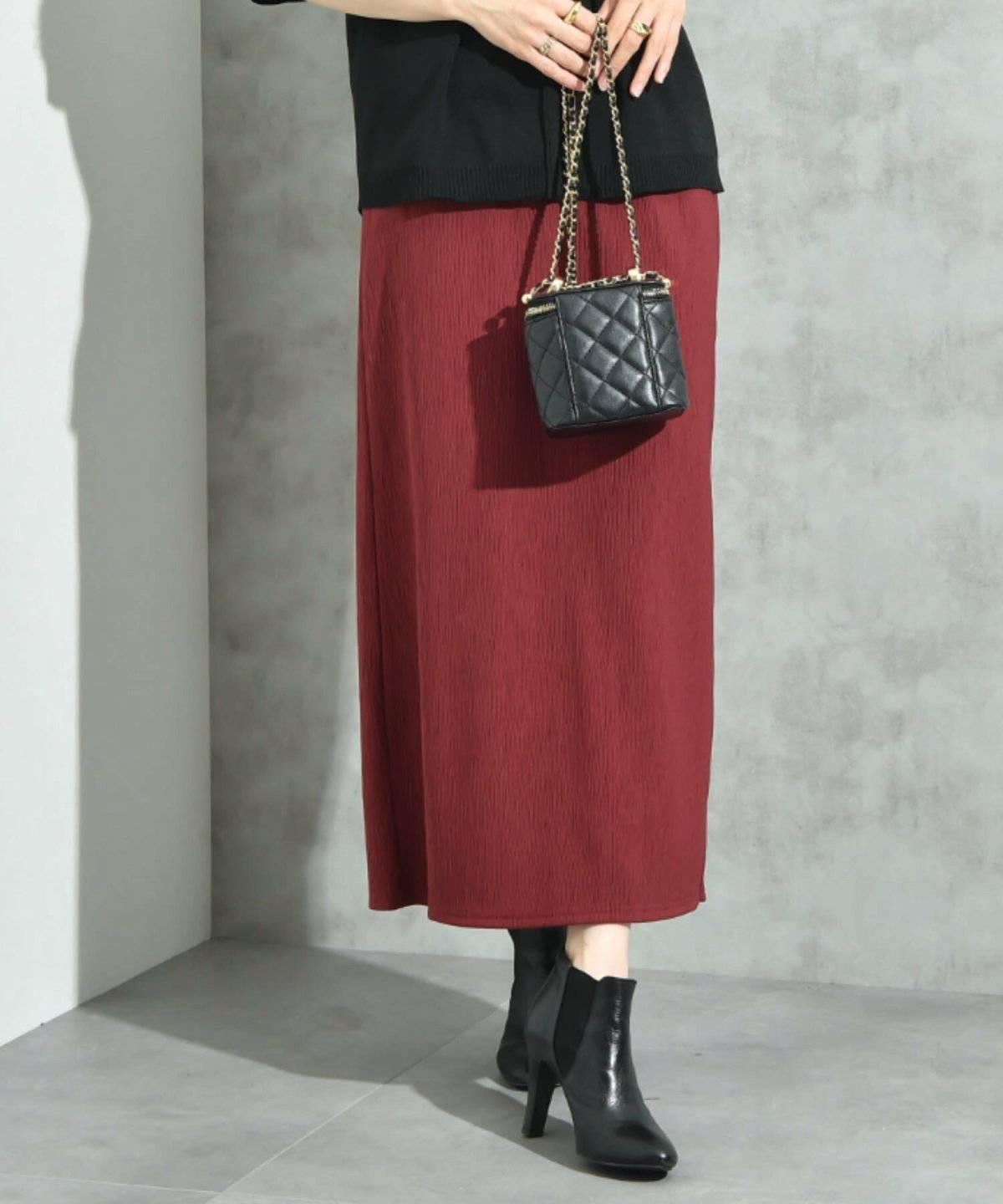 黒トップス✕ボルドースカートの女性