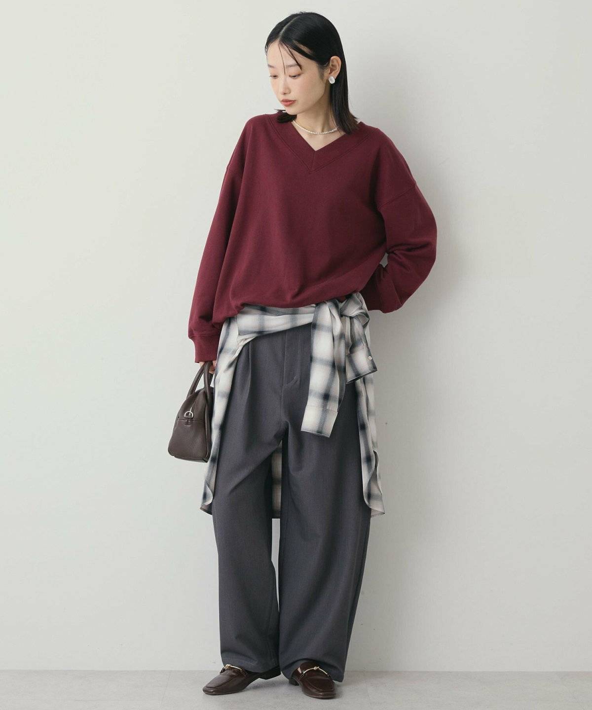 ボルドーニット✕グレーパンツの女性