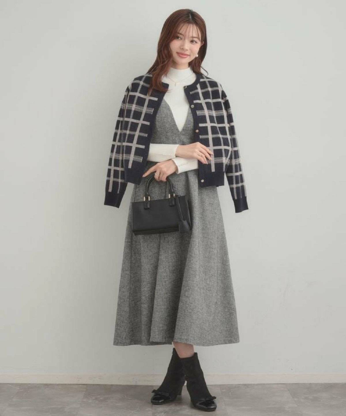 モノトーンコーデにグレーのカーディガンを羽織った女性