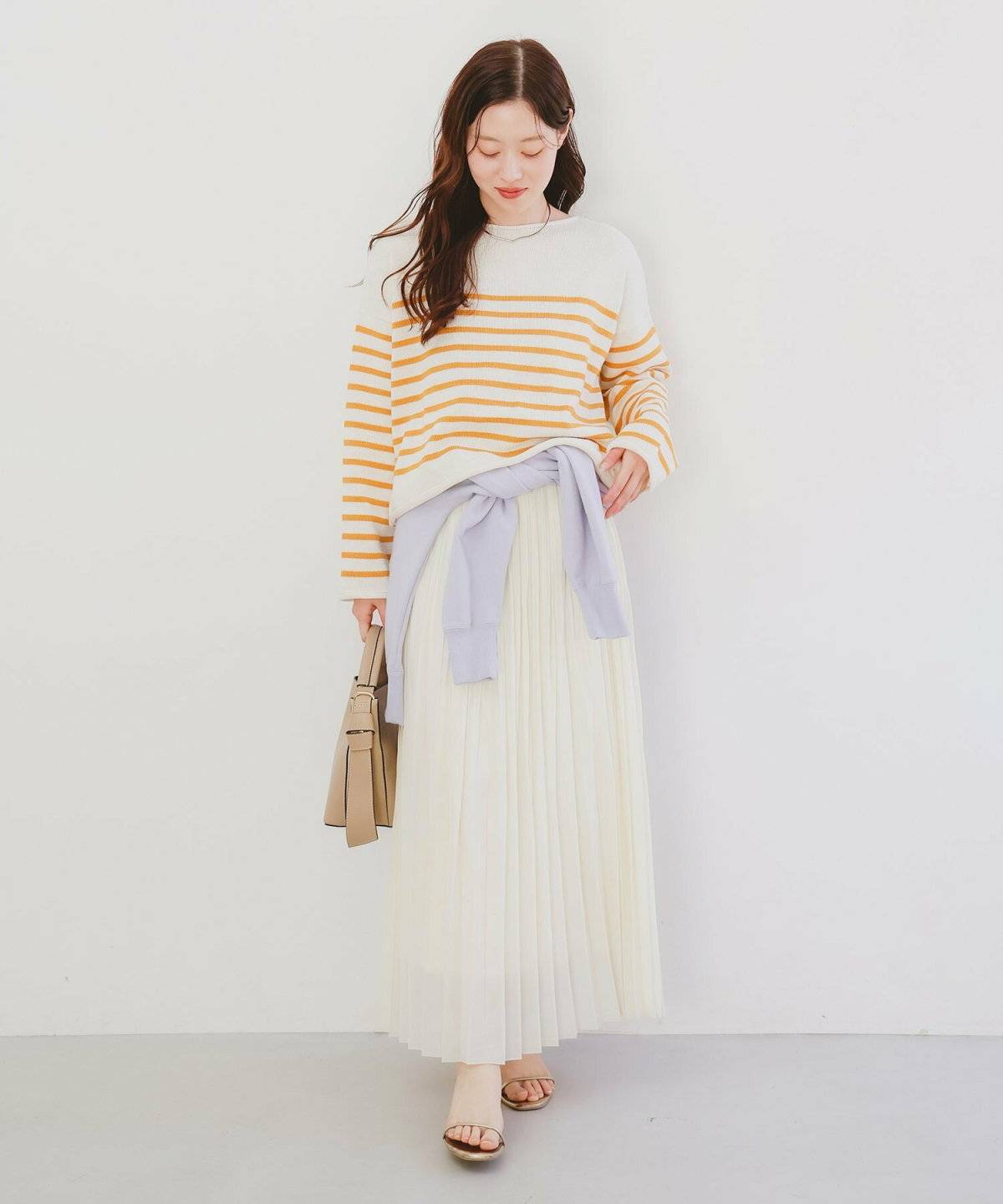 ボーダー柄ニットに白スカート合わせた女性