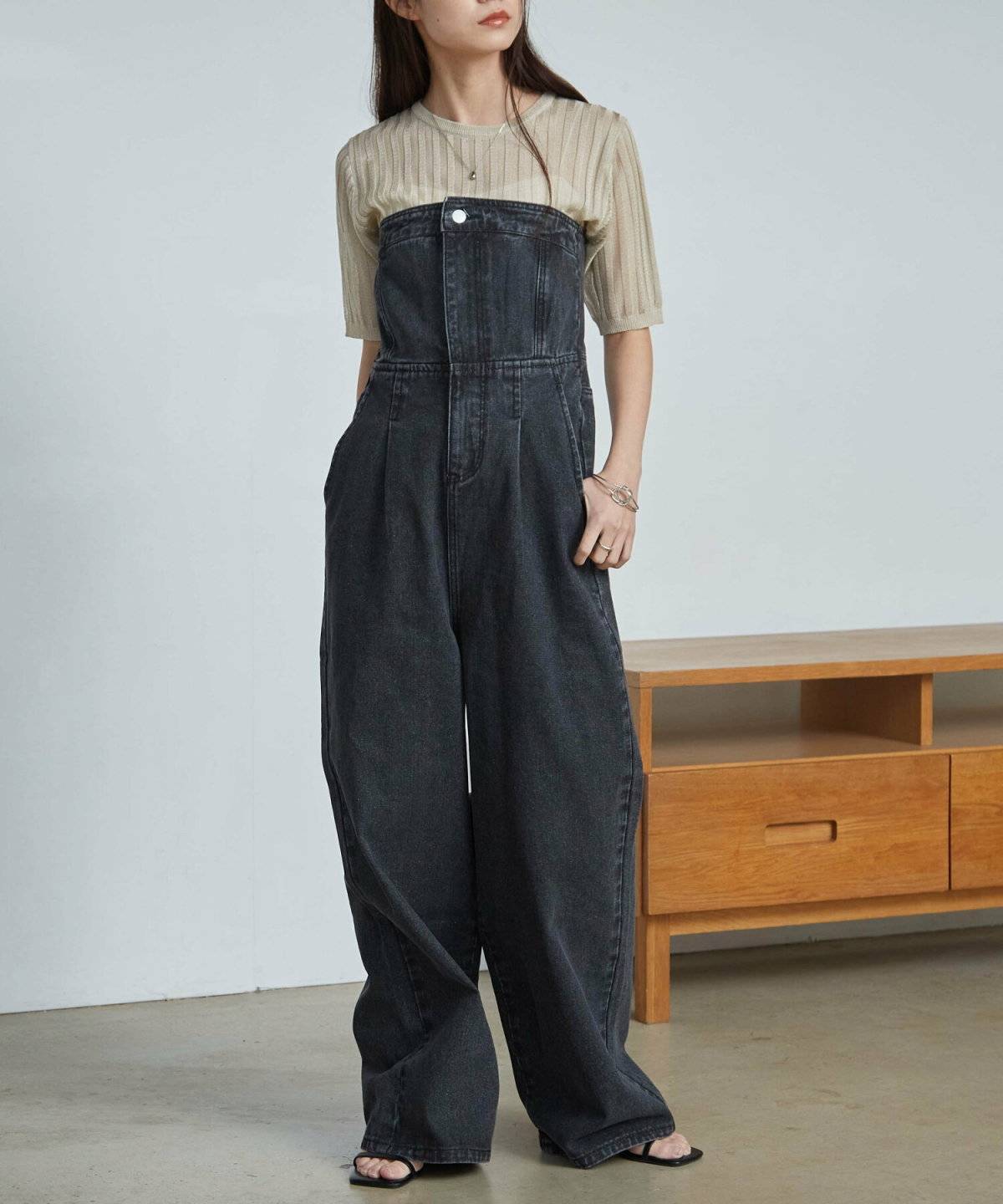 グリーンのトップスにサロペットを重ねた女性