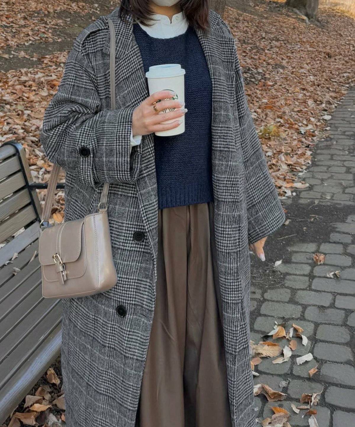 チェック柄のロングコートを羽織った女性