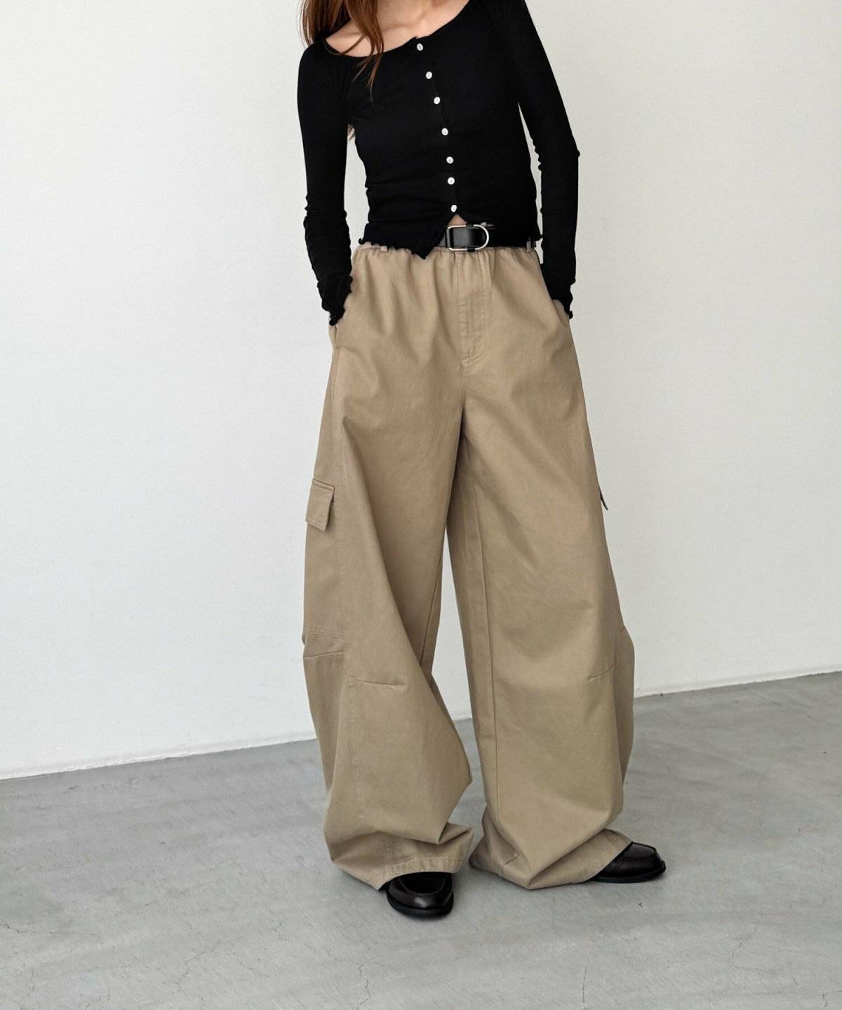 黒トップスとカーキのカーゴパンツを合わせた女性