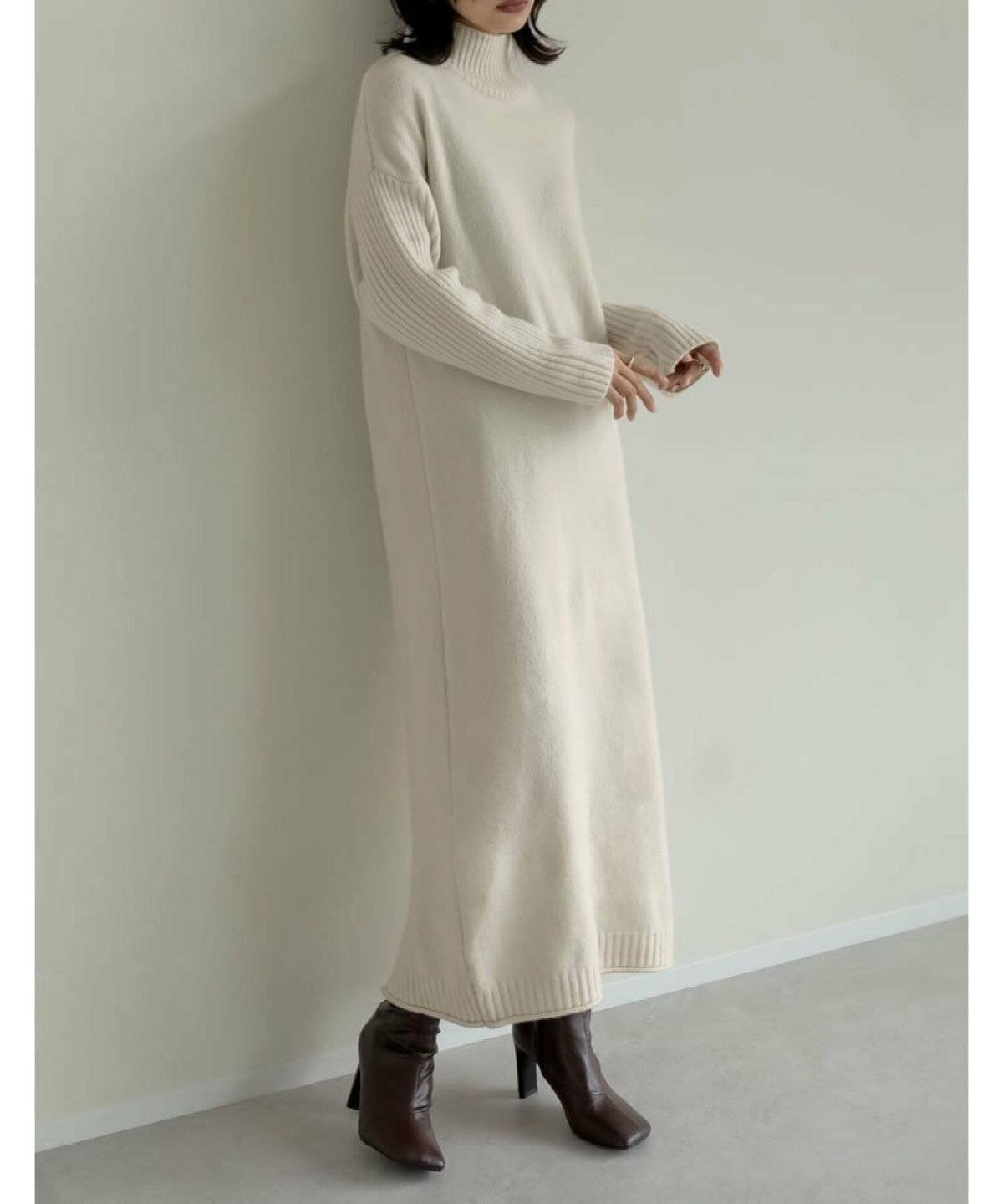 白のニットワンピースを着た女性