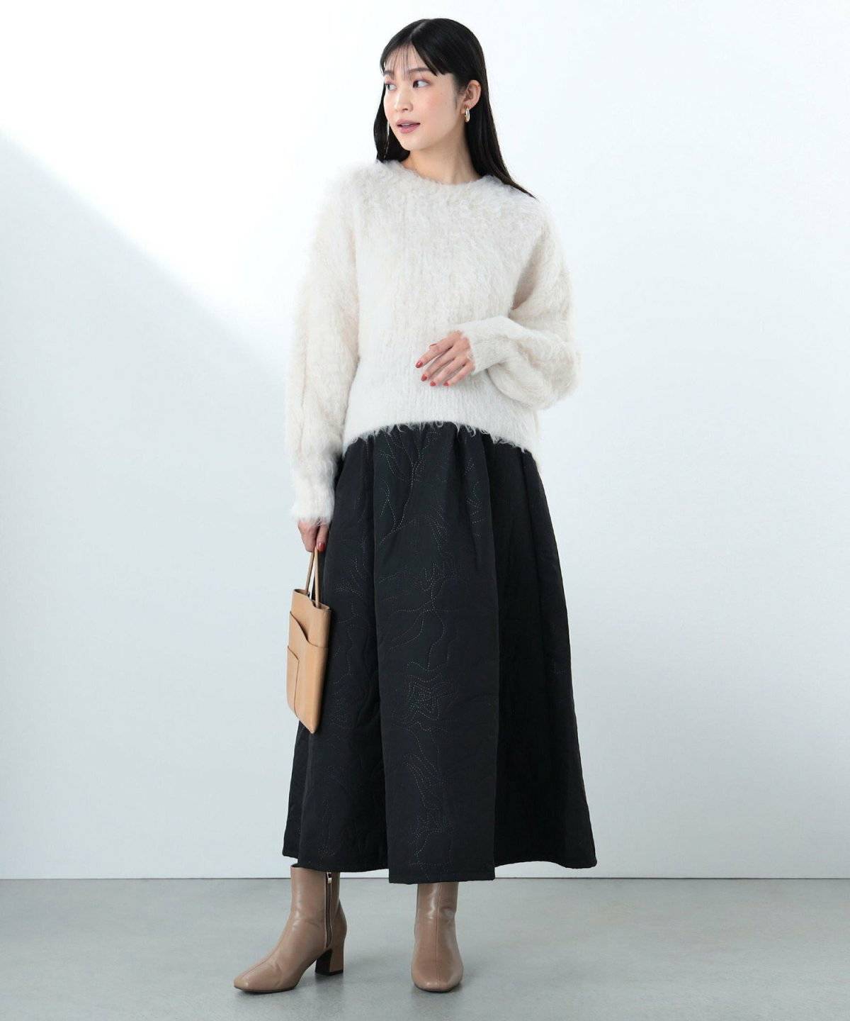 ニットに黒スカートを合わせた女性