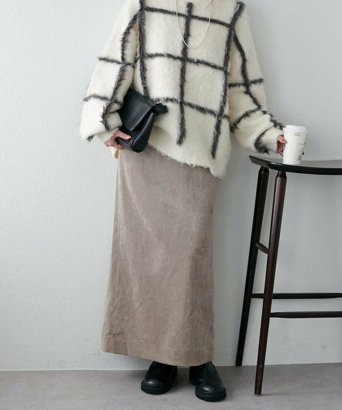 白ニットにベージュスカートを合わせた女性