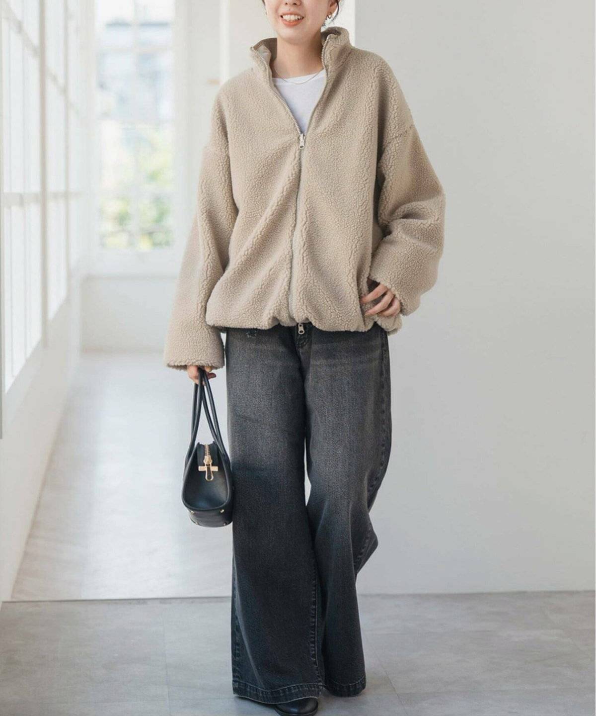 白トップスにデニムを合わせて白ジャケットを羽織った女性