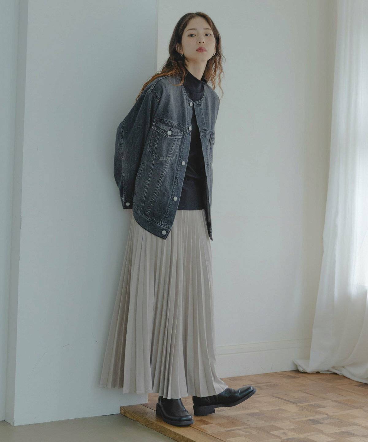 デニムジャケットを羽織ってスカートを合わせた女性