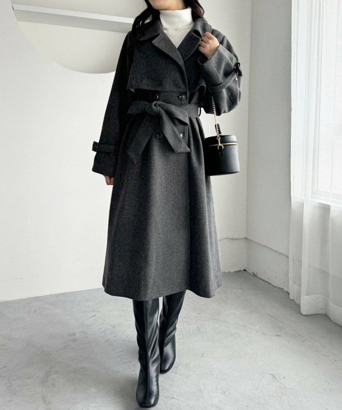ホワイトコーデにグレーのコートを羽織った女性