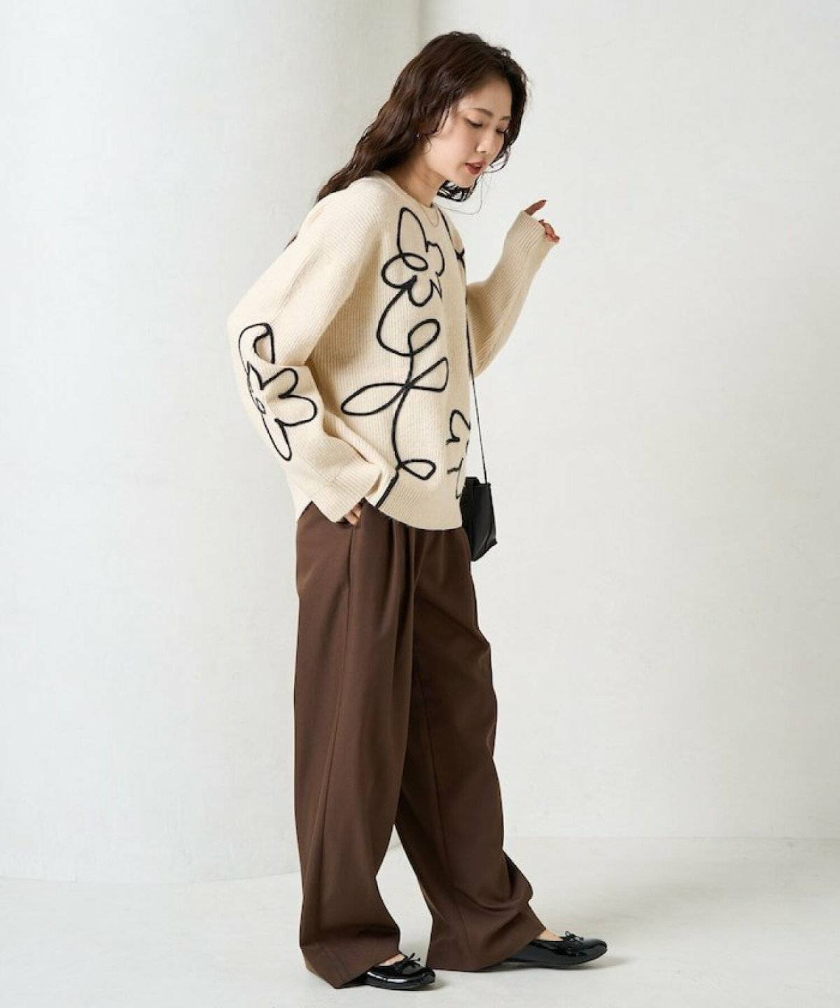 柄ニットにパンツを合わせた女性