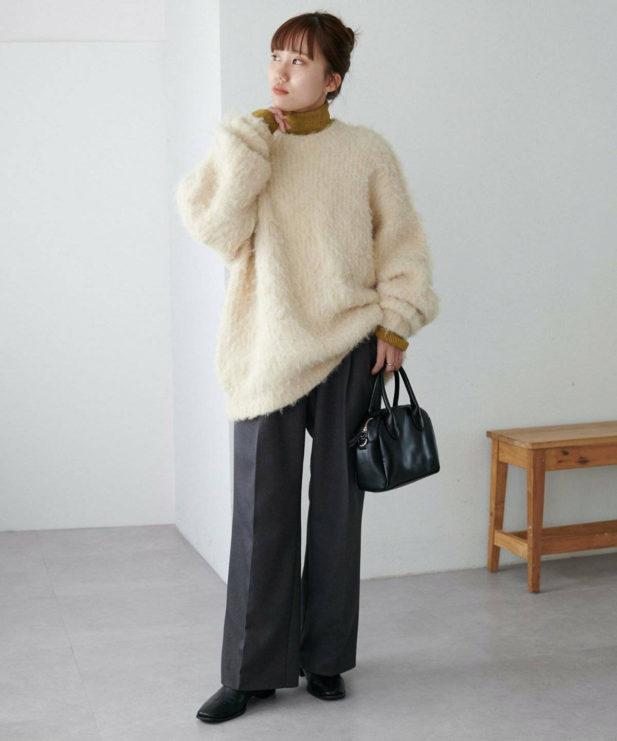 ハイネックニットとニットを重ねてパンツを合わせた女性