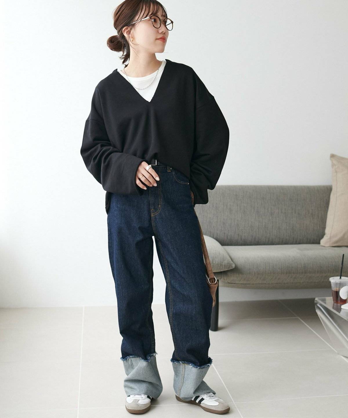 黒プルオーバーにデニムを合わせた女性
