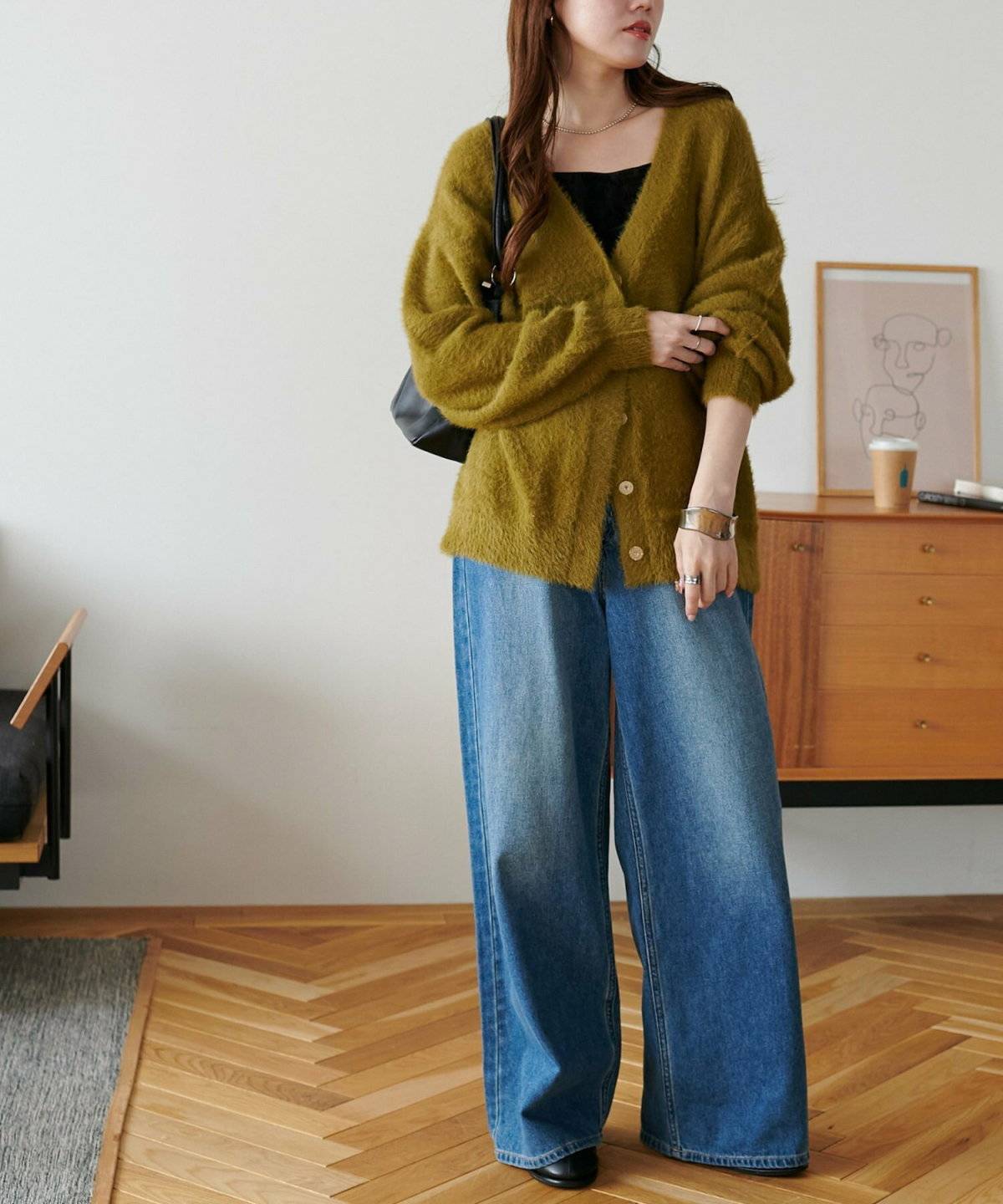 イエローのカーディガンにデニムを合わせた女性