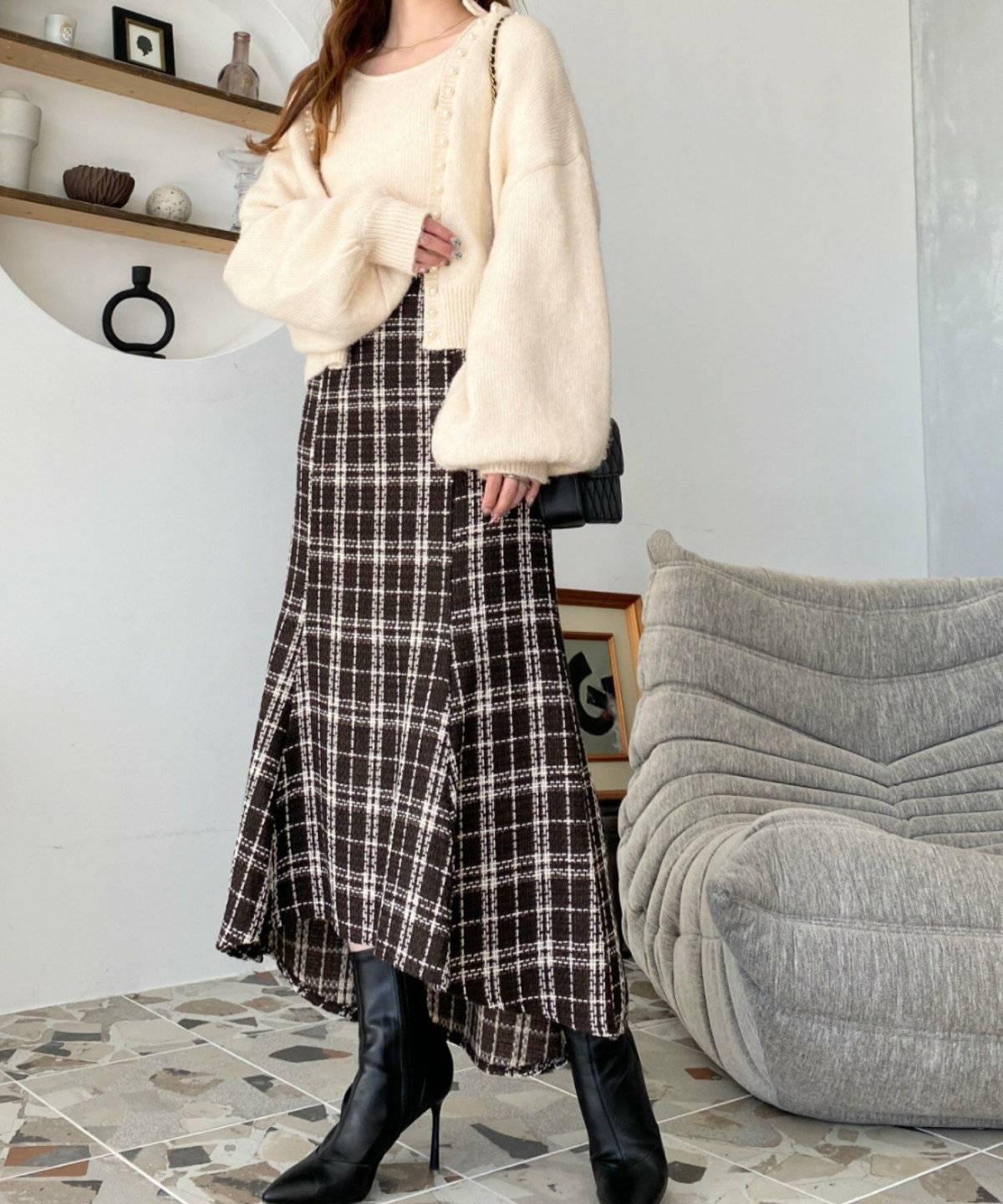 白ニットにブラウンのスカートを合わせた女性