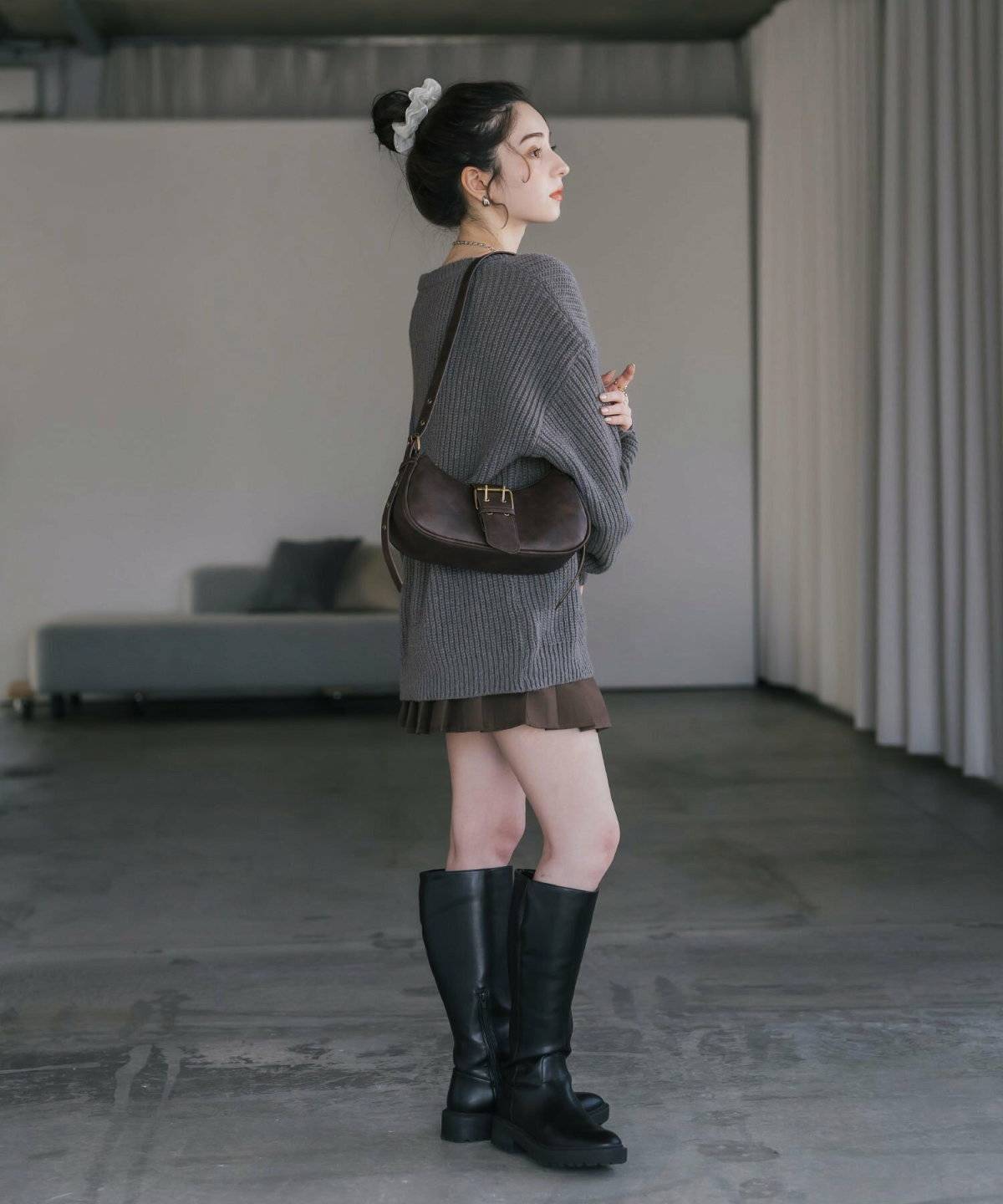 グレーのニットにスカートを合わせた女性