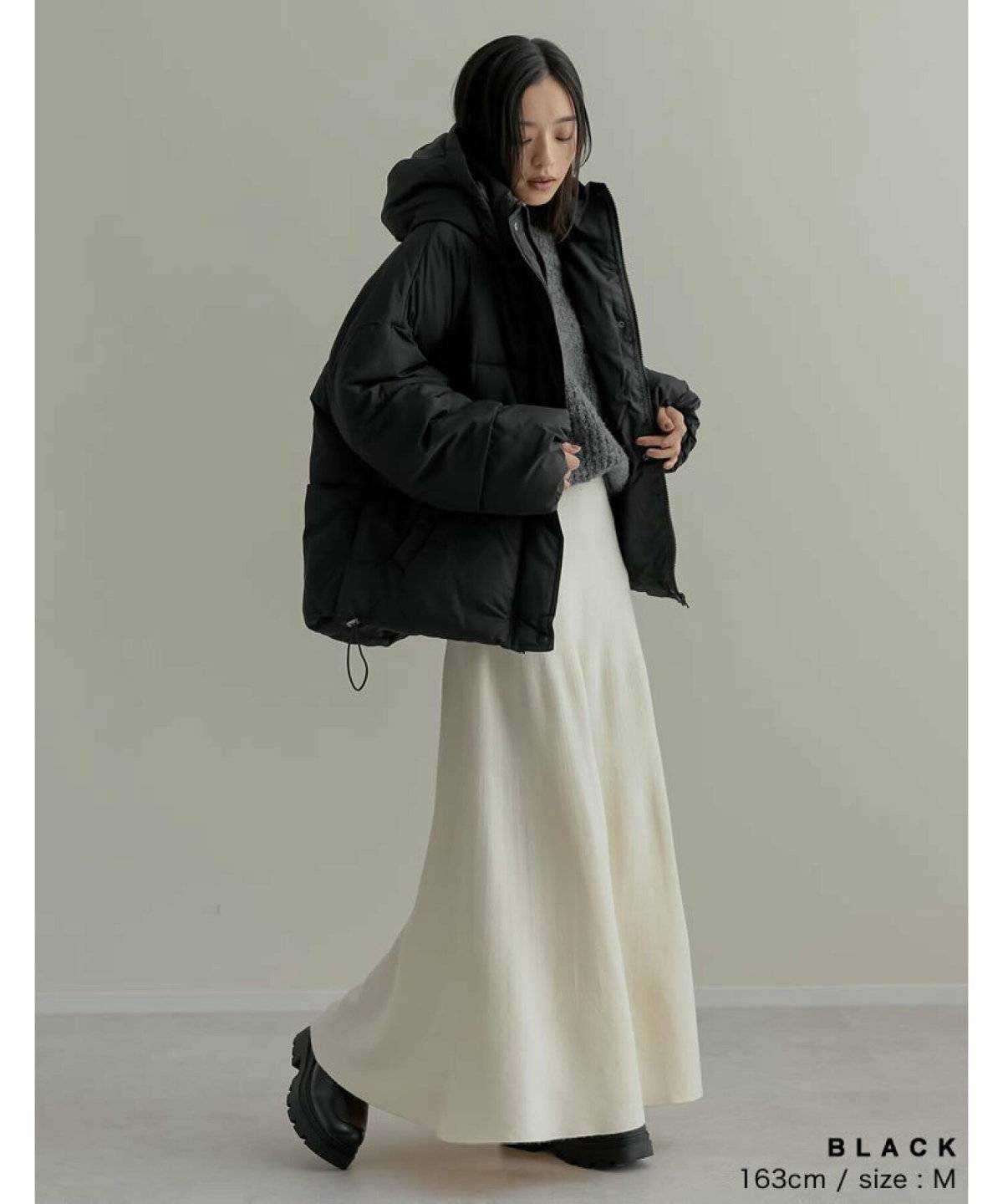 ダウンに白スカートを合わせた女性