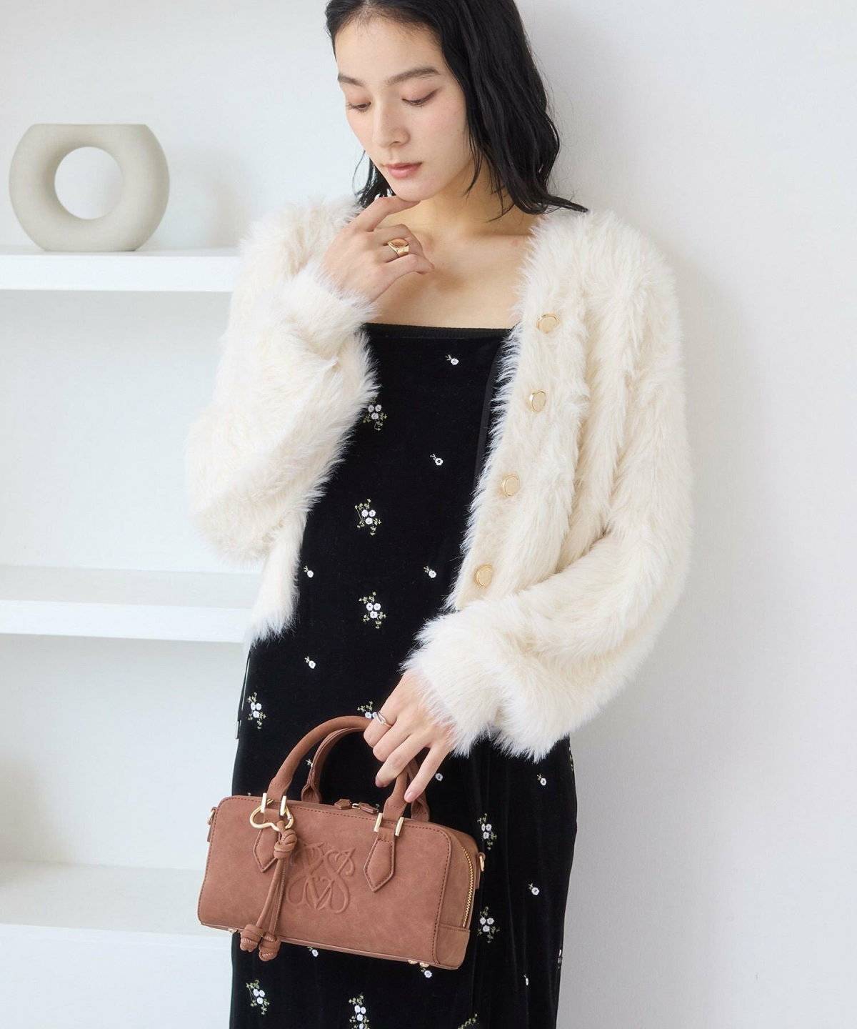 白のボアアウターにベロアワンピースを合わせた女性