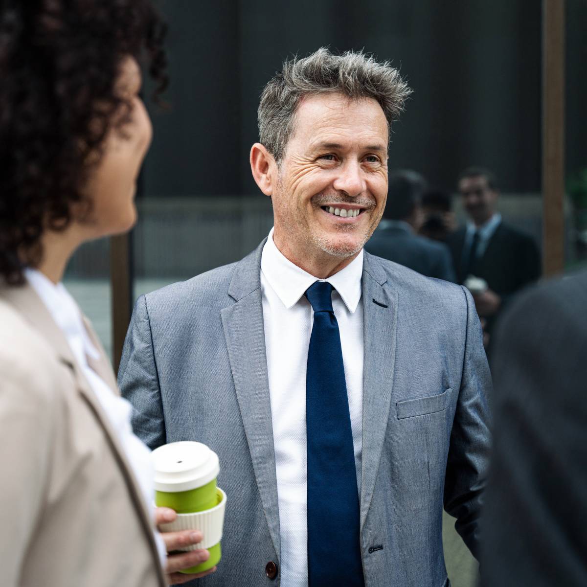 外で同僚たち話す男性