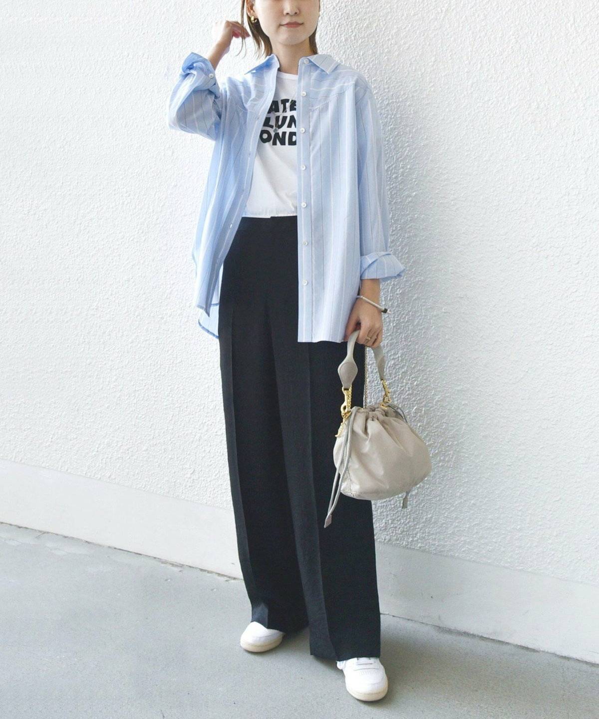 モノトーンコーデにストライプ柄のシャツを羽織った女性