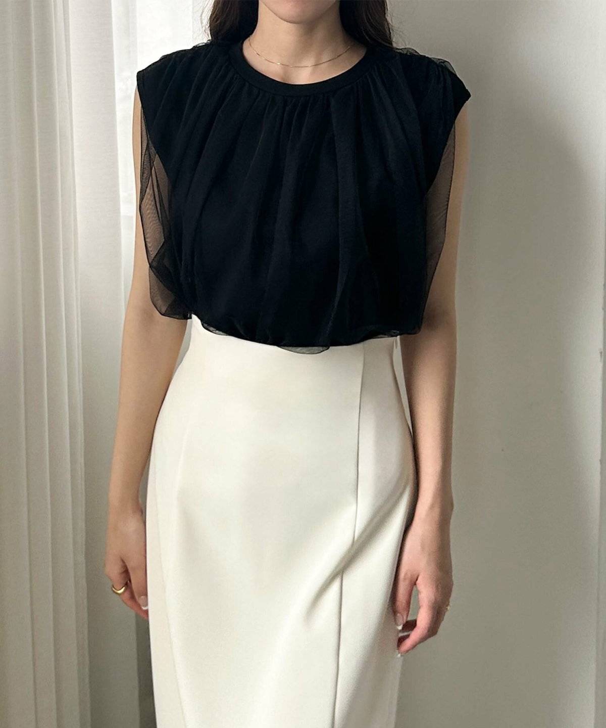 黒トップスにスカートを合わせた女性