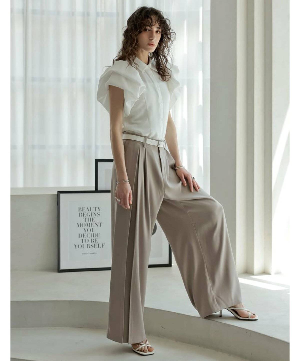 ブラウスにベージュのパンツを合わせた女性