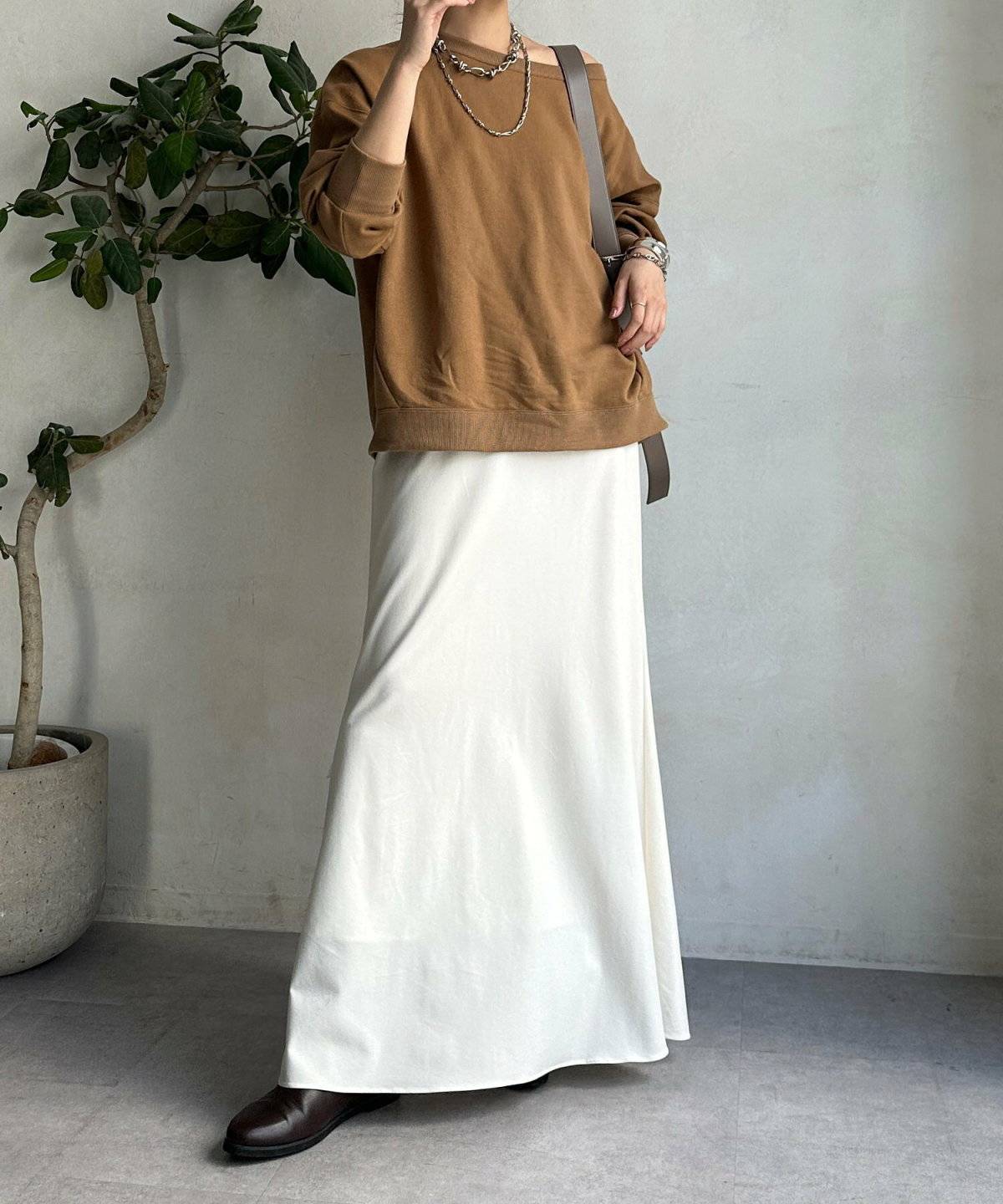 キャメルプルオーバー✕白スカートの女性