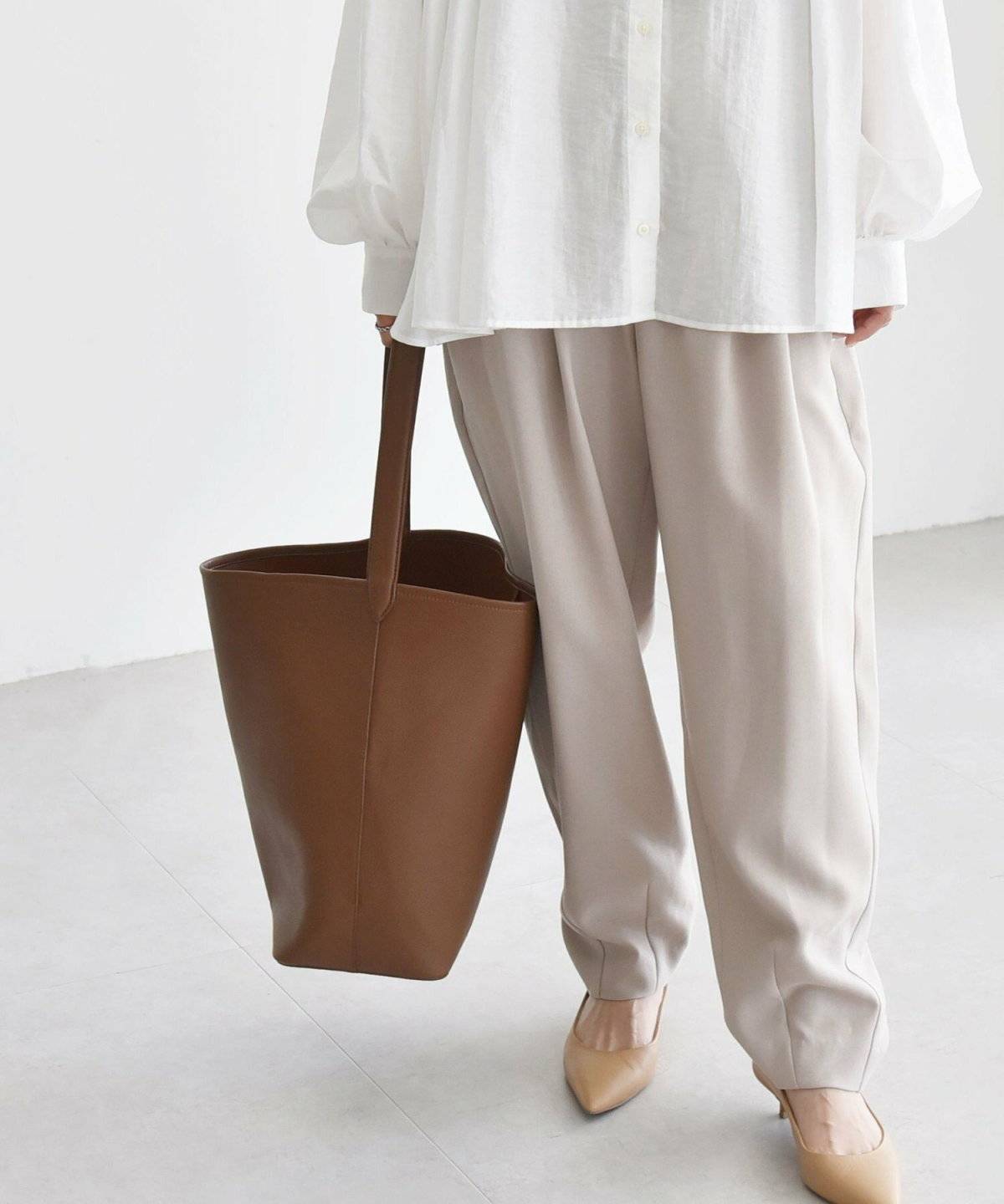 キャメルハンドバッグ✕白のワントーンコーデの女性