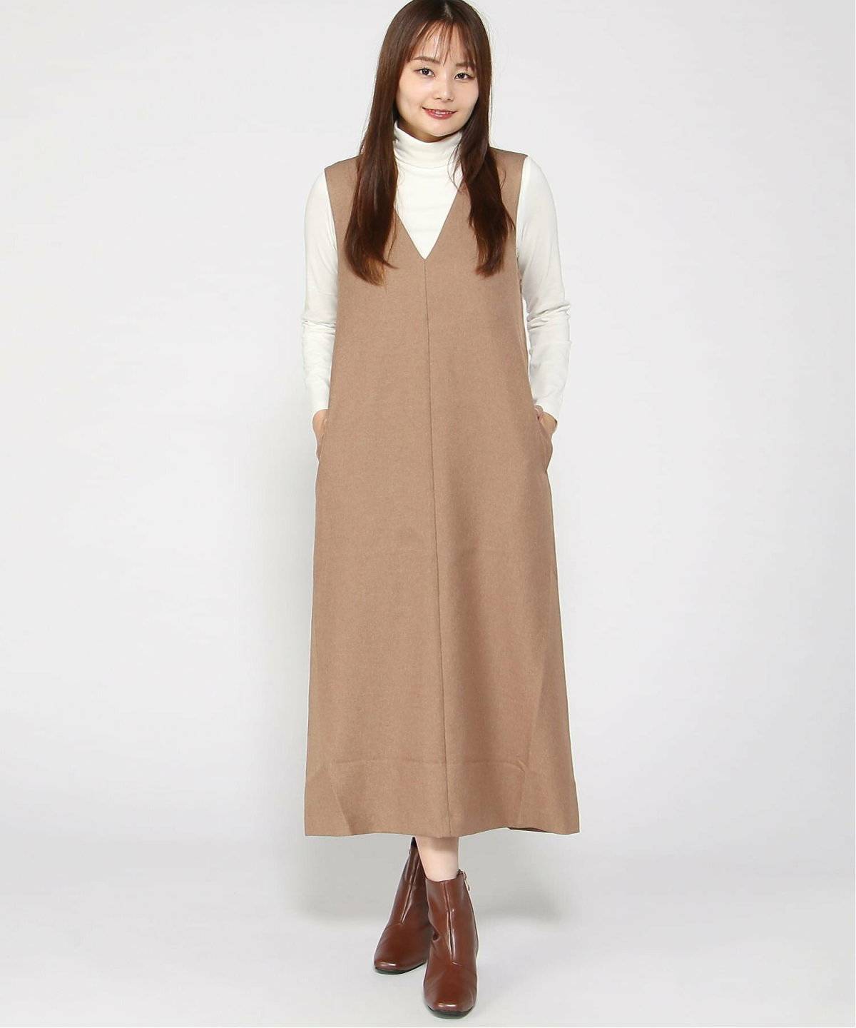 キャメルジャンパースカート✕白ニットの女性