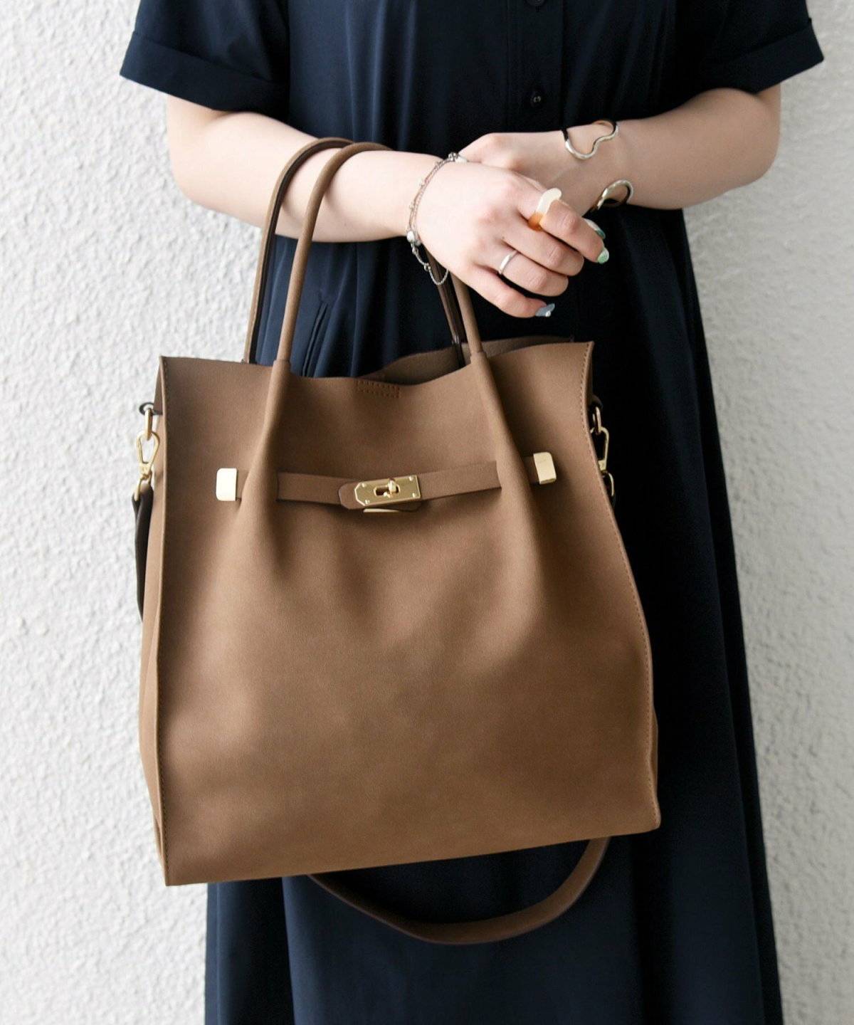 キャメルハンドバッグ✕黒のワントーンコーデの女性