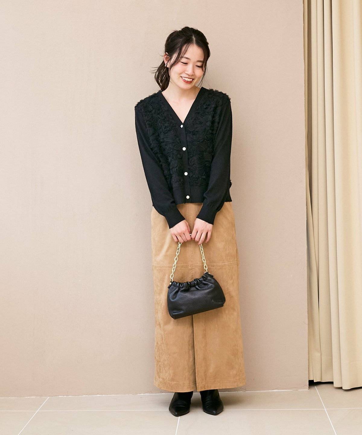 キャメルスカート✕黒のシアーブラウスの女性