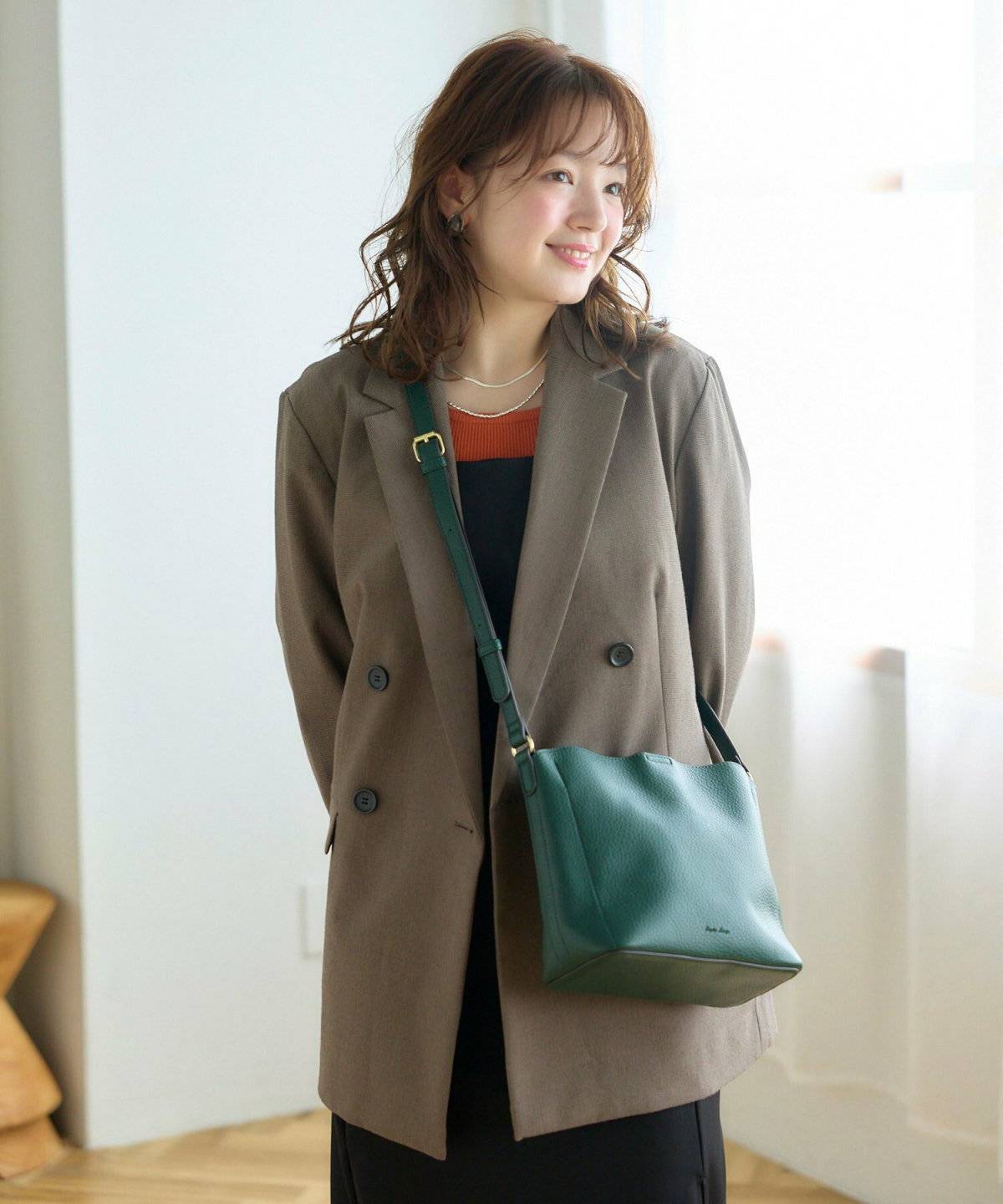 ダークグリーンのバッグを持った女性