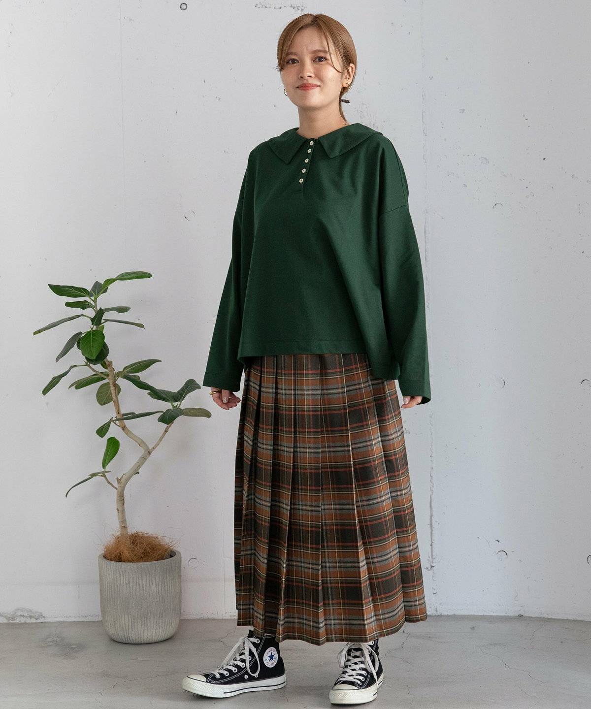 ダークググリーンニット✕茶色スカートの女性