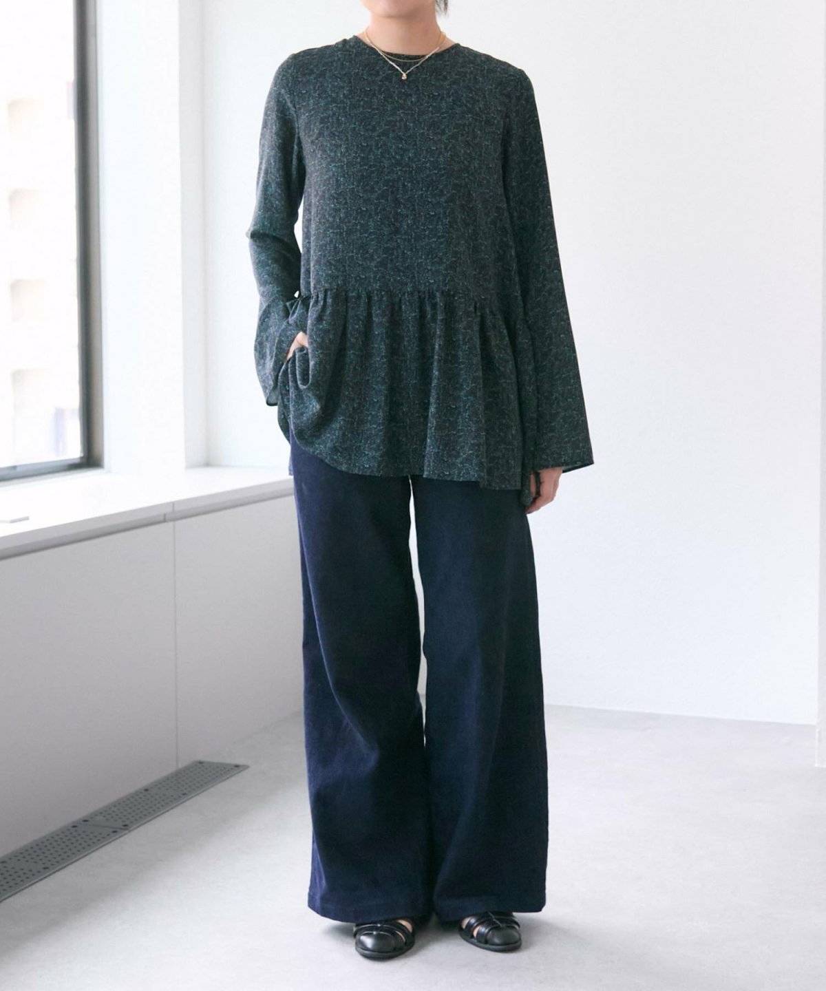 ダークグリーントップス✕ネイビースカートの女性