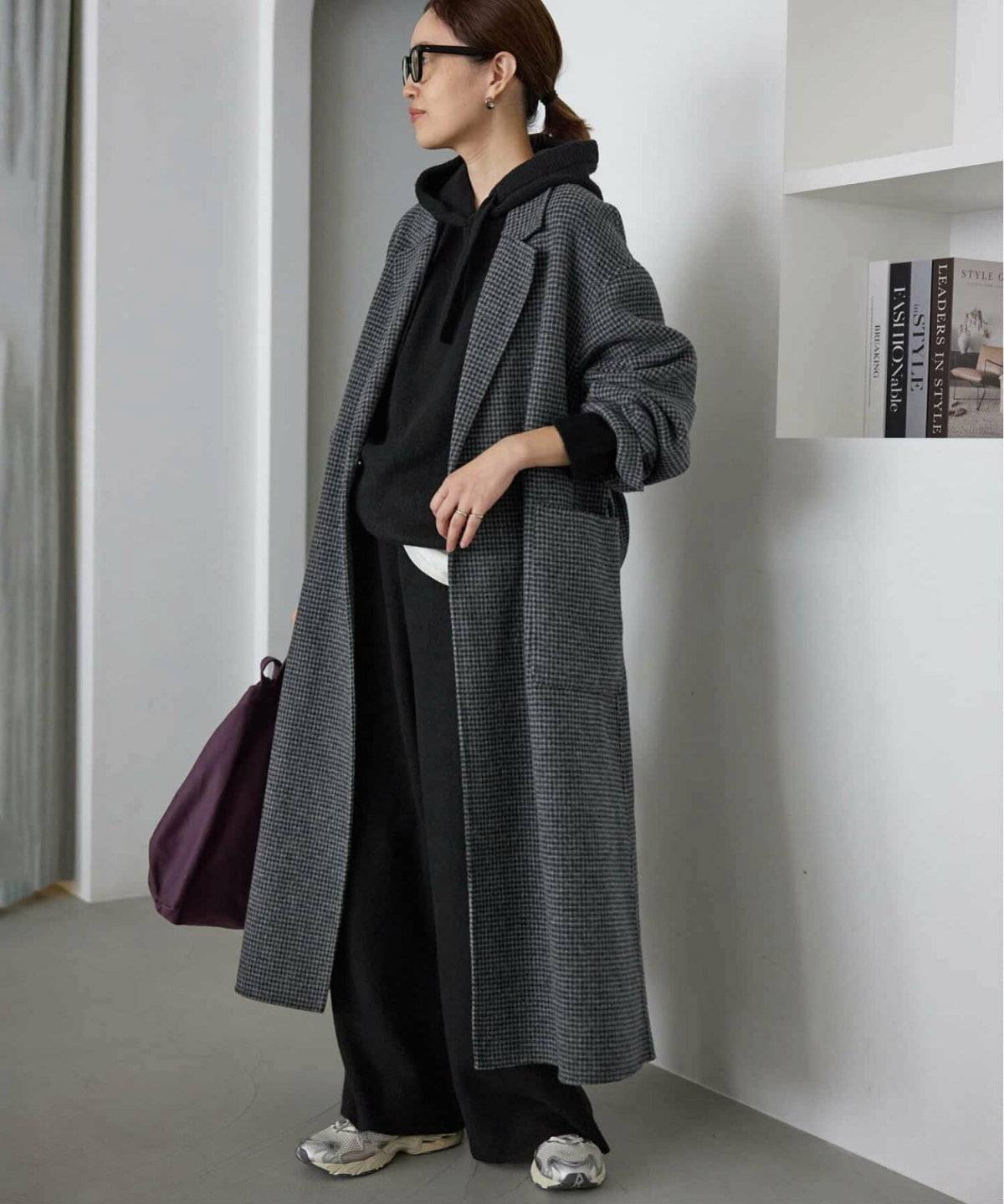 ブラックコーデにグレーコートを羽織った女性