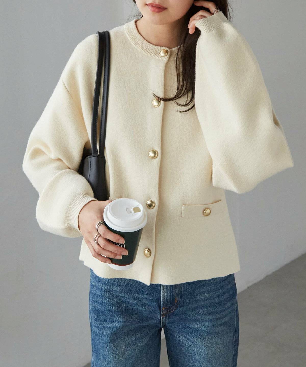 白カーディガンにデニムを合わせた女性