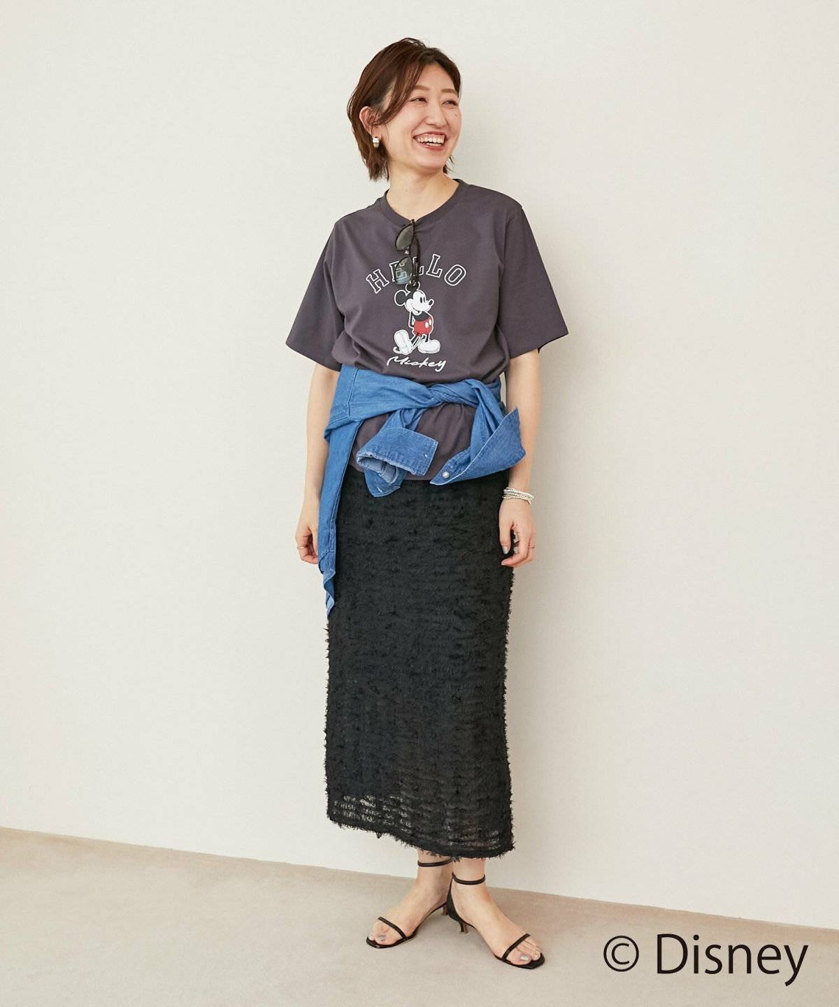 モノトーンコーデにデニムジャケットを羽織った女性