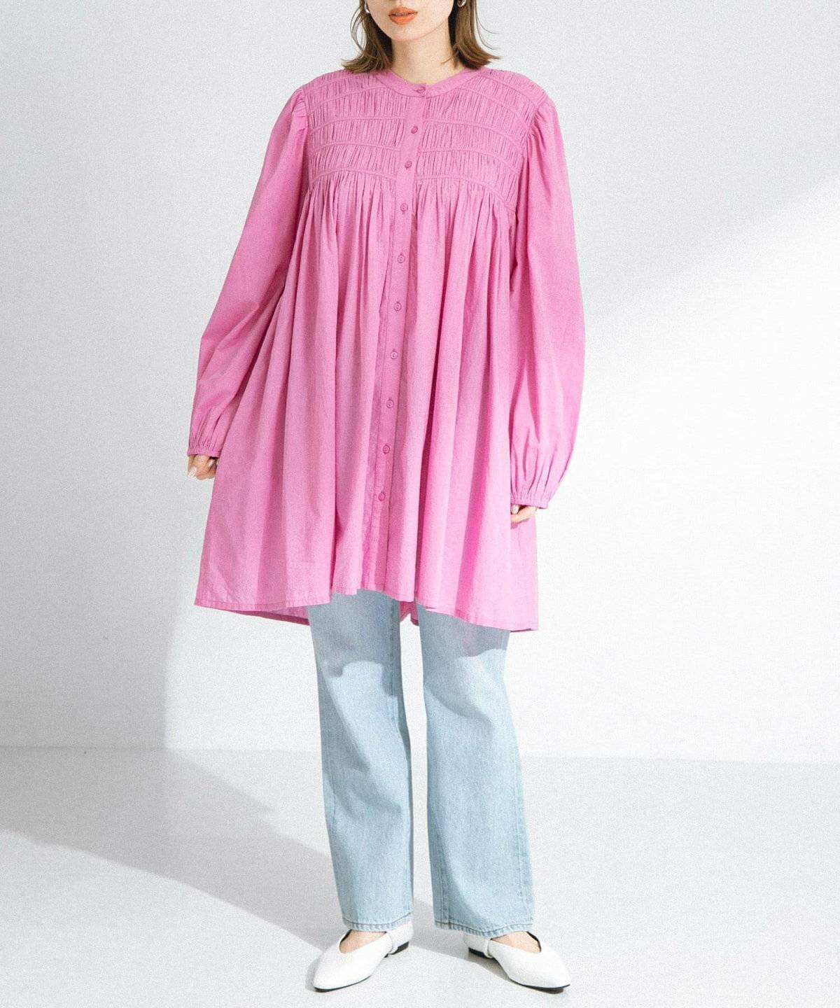 ピンクのミニワンピースにデニムを合わせた女性