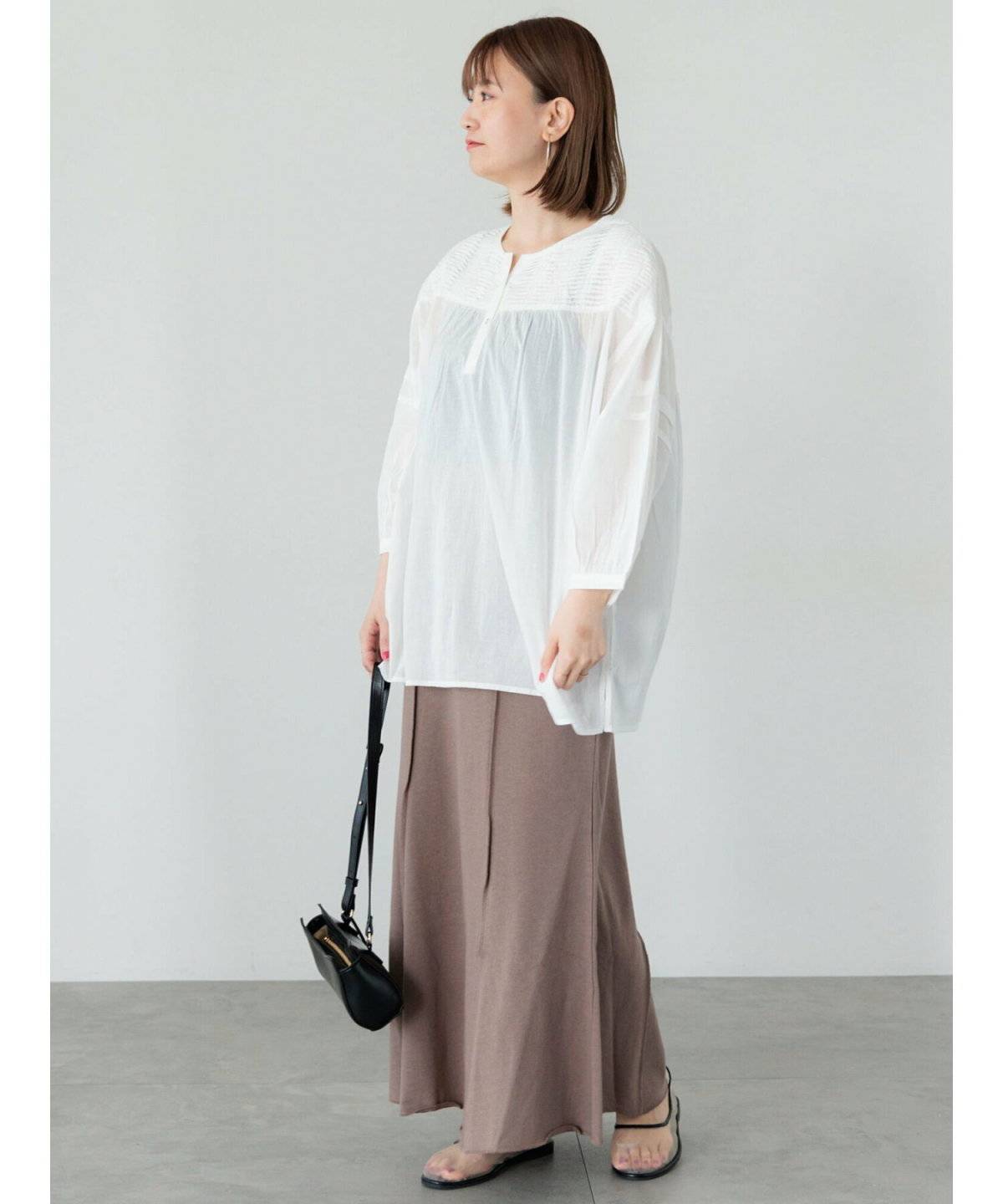 白ブラウスにブラウンのスカートを合わせた女性
