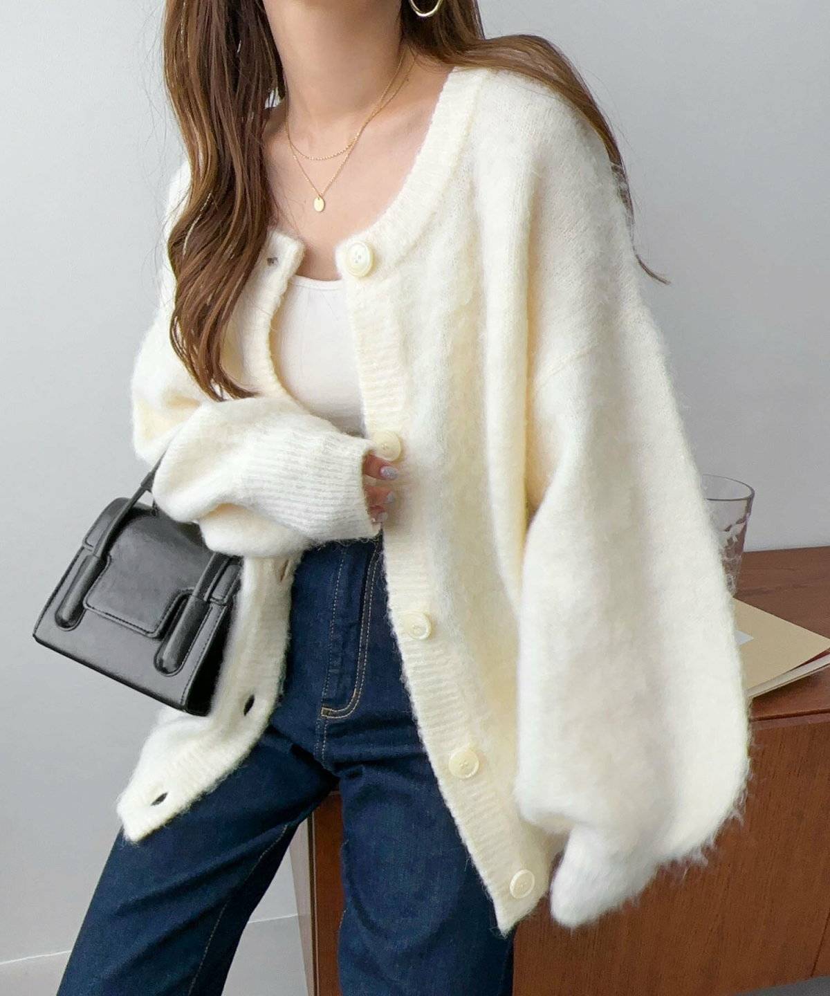 白カーディガンにデニムを合わせた女性