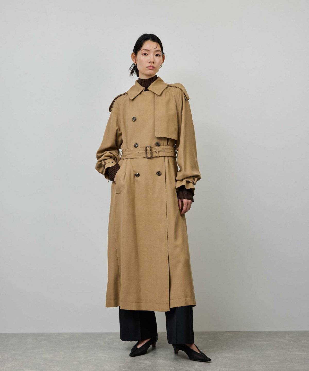 ベージュのトレンチコートを着た女性