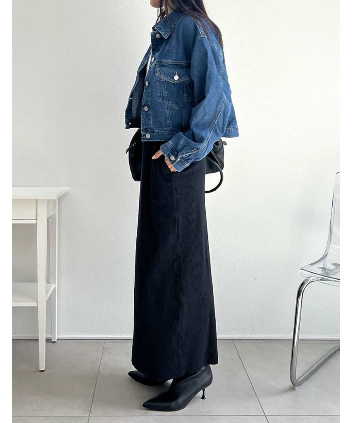 デニムジャケットに黒スカートを合わせた女性
