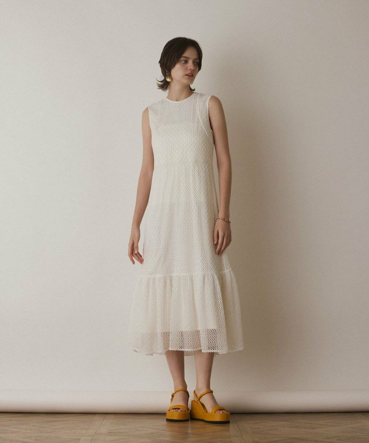 メッシュ編みニットワンピースを着た女性