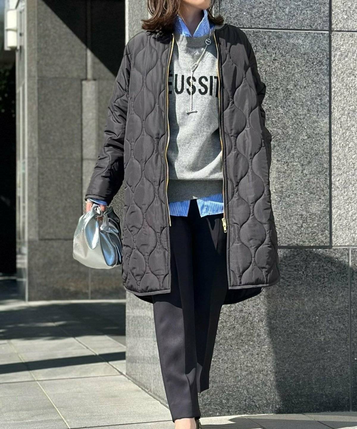 モノトーンコーデにアウターを羽織った女性