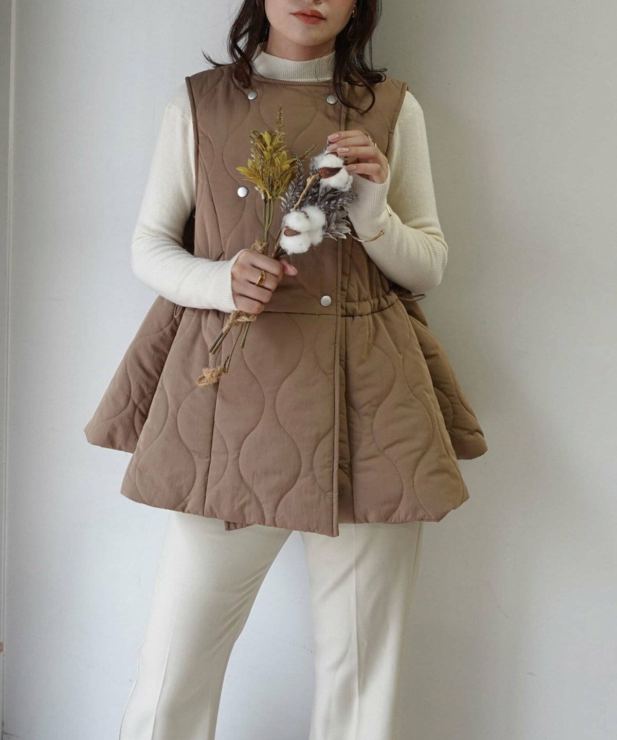 ベージュのベストを重ねた女性