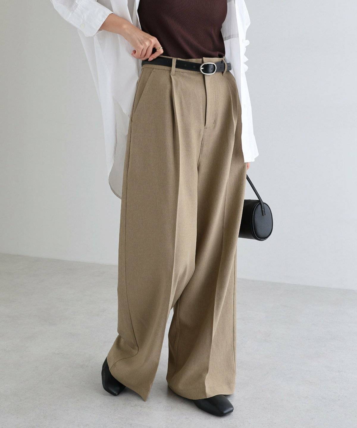 白シャツにベージュのパンツを合わせた女性