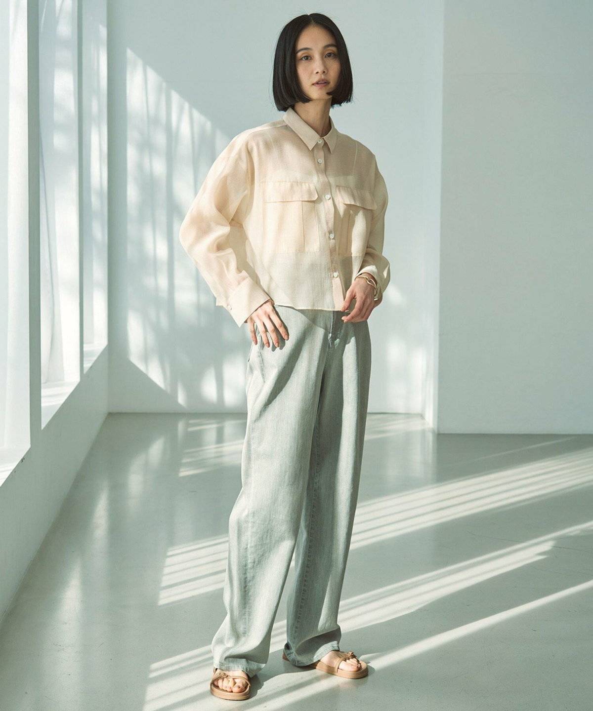 イエローのシャツにグリーンのパンツを合わせた女性