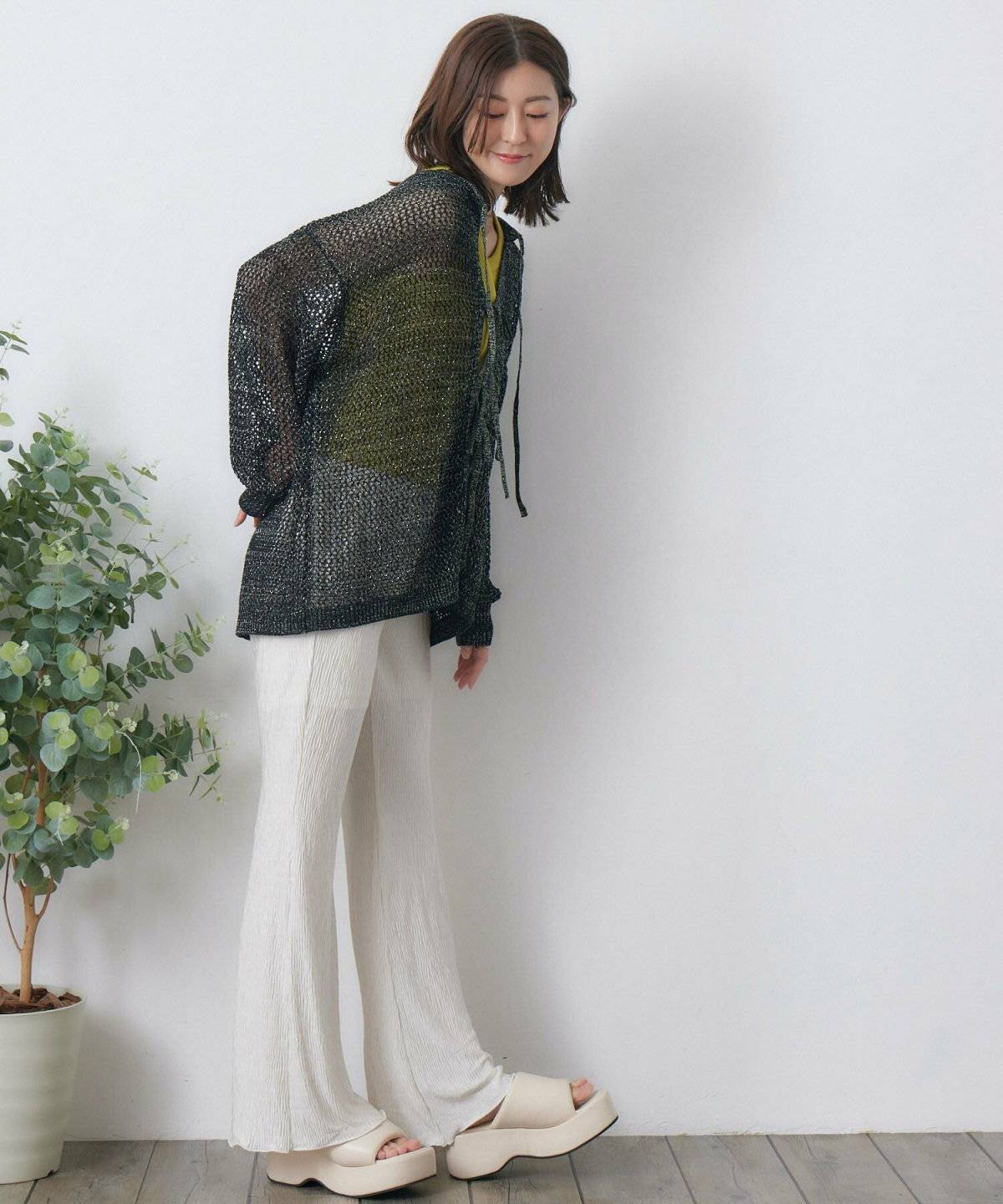 黒トップスにパンツを合わせた女性