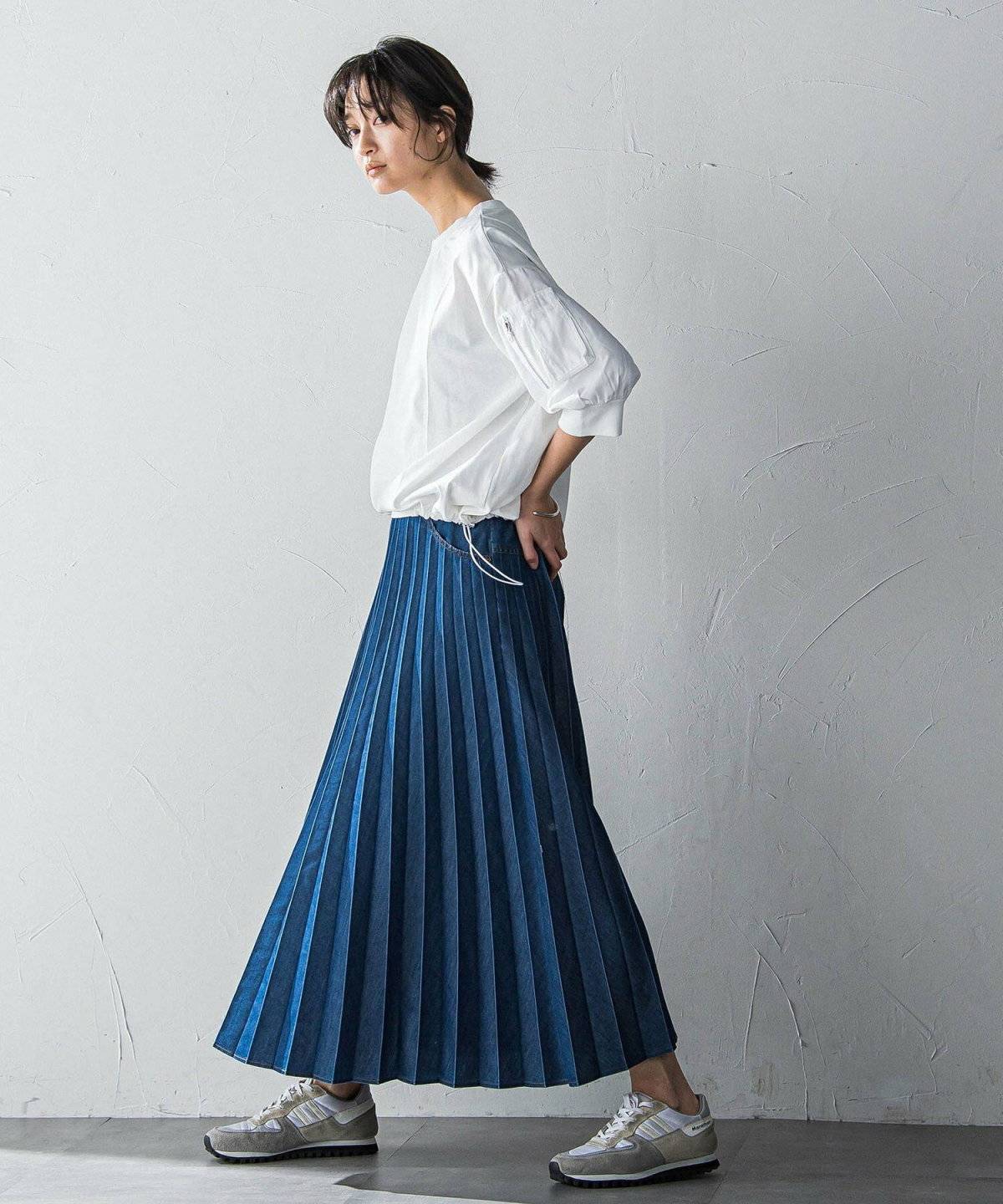 白トップスにデニムスカートを合わせた女性