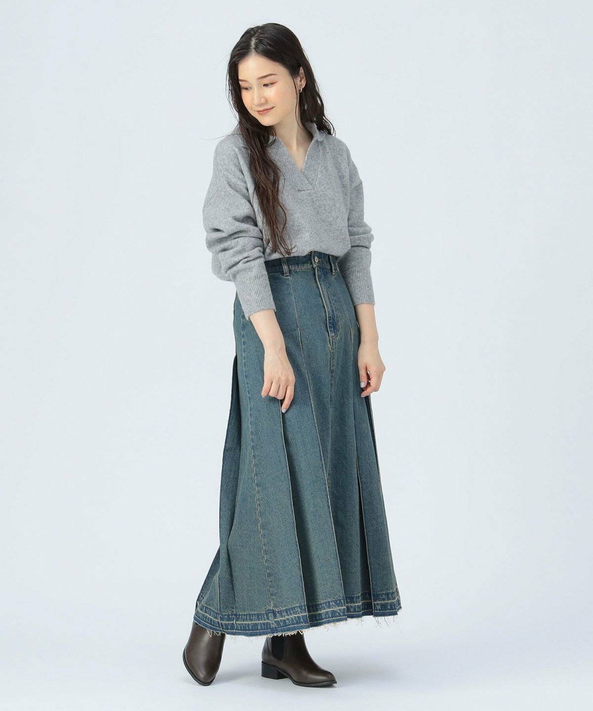 ニットにデニムスカートを合わせた女性